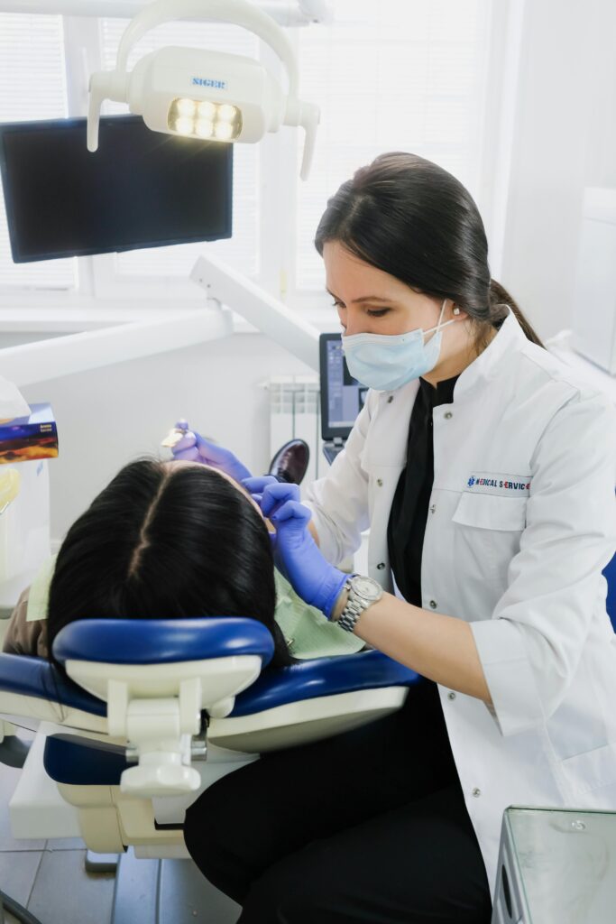 Dentist performing dental check-up in modern clinic setting.